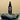 Black bottle with floral design labeled 'LOA SKIN' on a rock with a beige background