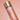 Skin tone correcting serum bottle with gold cap on a pink background