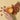 Almonds and a glass of almond oil on a beige background