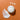 White cream jar with open lid and scattered cream on an orange background